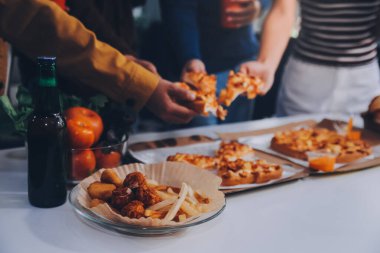 Pizza yiyen bir grup genç arkadaş. Ev partisi..