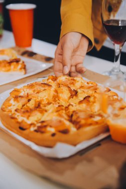 Mutlu arkadaşlar, aynı dairede pizza yemeden önce birayla kadeh kaldırır..