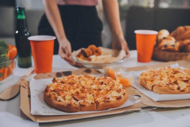 Ekmek ve çöreklerle sepeti tutan genç bir kadının yakın çekim görüntüsü.