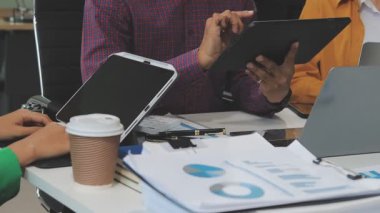 Bir grup profesyonel, finansal tabloları ve şirket raporlarını inceliyor..