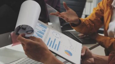 Bir grup profesyonel, finansal tabloları ve şirket raporlarını inceliyor..