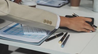 Çağdaş bir ofis ortamında finansal haritaları ve iş raporlarını inceleyen bir profesyonel ekip.