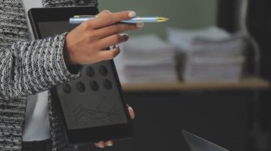 Modern ofiste finansal tablolar ve iş raporlarıyla çalışan bir grup iş adamı