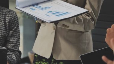 Modern ofiste finansal tablolar ve iş raporlarıyla çalışan bir grup iş adamı