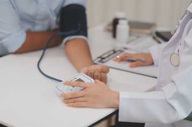 Doktor kadın nabız sayacını hastanın basıncını ölçmek için kullanıyor. Tıbbi kontrol konsepti..