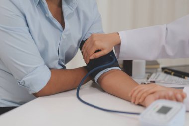 Doktor kadın nabız sayacını hastanın basıncını ölçmek için kullanıyor. Tıbbi kontrol konsepti..