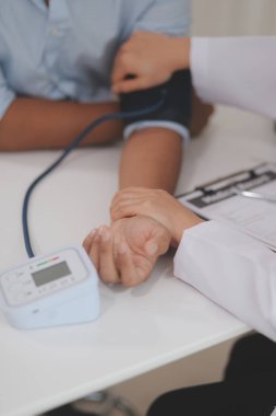 Doktor kadın nabız sayacını hastanın basıncını ölçmek için kullanıyor. Tıbbi kontrol konsepti..