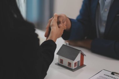 Emlak acentesi kontrat imzalandıktan sonra müşteriyle tokalaşıyor