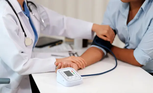 Doktor kadın nabız sayacını hastanın basıncını ölçmek için kullanıyor. Tıbbi kontrol konsepti..