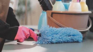 Kadın evi sünger ve bezle temizliyor.