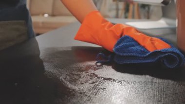 Mavi lastik eldivenli adam temizlik yapıyor.