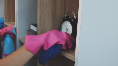 Mavi eldivenli kadın mutfağı tahta bir tahta ve bir bez parçasıyla yıkıyor.