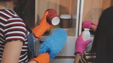 Genç bayan mutfağı temizliyor.