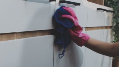 Bir paçavrayla pencereyi temizleyen kadının ellerini kapat.