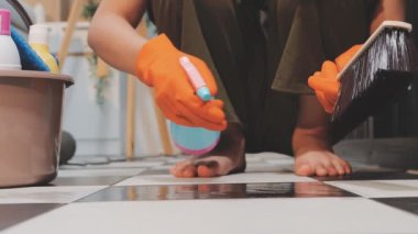 Yerleri paçavra ve süngerle temizleyen kadın.