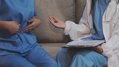 Steteskoplu bir doktor ve hasta panoda bir şey tartışıyor..