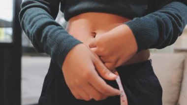 Belini ölçen genç bir kadın.