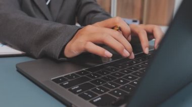 Düşünceli ve ciddi Asyalı işadamı iş yerinde dizüstü bilgisayar kullanıyor.