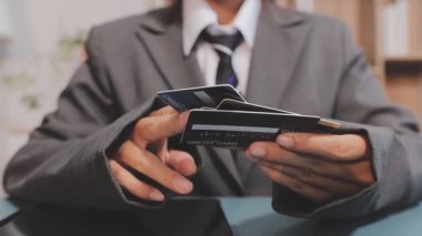 Asyalı iş kadını, modern ofisin kredi kartlarını elinde tutuyor. 