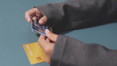 Asyalı iş kadını, modern ofisin kredi kartlarını elinde tutuyor. 