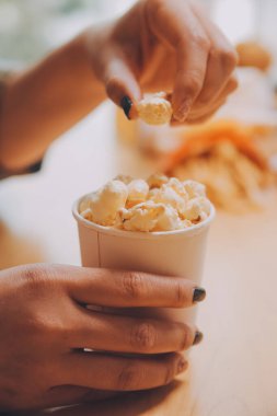 Elinde patlamış mısır kasesi tutan bir kadın.