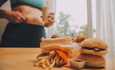 Yemek ya da değil. Burger bakarak cheerless tombul kadın yemek ya da değil düşünme