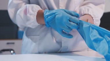 Mavi eldiven giyen genç kadın bilim adamının yakın çekim görüntüsü, son kullanma tarihine hazırlanıyor. 