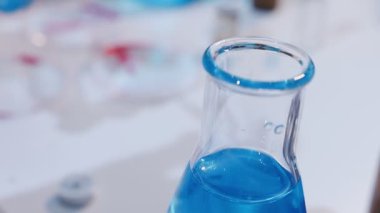 Genç bilim kadını modern bir araştırma laboratuvarında kimyasallarla dikkatlice çalışıyor..