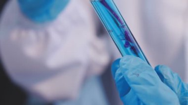 Gelişmiş bir laboratuarda kimyasal maddelerle ilgilenen bir kadın araştırmacının detaylı görüntüleri..