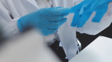 Beyaz eldivenli doktor dizüstü bilgisayarla çalışıyor..