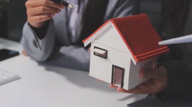 Emlakçı, sözleşmeden sonra ev modelini müşteriye veriyor.