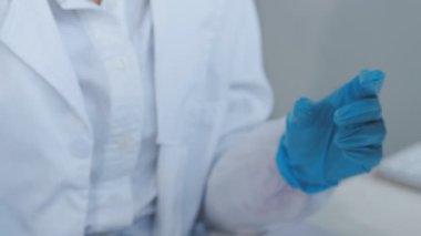 Laboratuvar önlüklü bilim adamı mikroskopla çalışıyor.