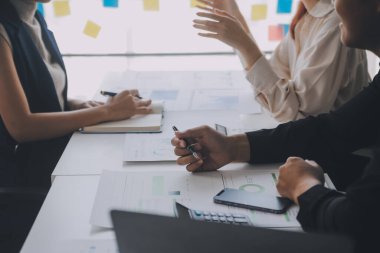 Finansal analistler, şirketlerin başarılı takım çalışmalarının sonuçlarını gösteren bir toplantıda bir dijital tablet planlama yatırım projesinin ticari mali raporlarını analiz ediyorlar..