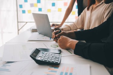 Finansal analistler, şirketlerin başarılı takım çalışmalarının sonuçlarını gösteren bir toplantıda bir dijital tablet planlama yatırım projesinin ticari mali raporlarını analiz ediyorlar..