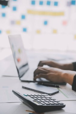 Finansal analistler, şirketlerin başarılı takım çalışmalarının sonuçlarını gösteren bir toplantıda bir dijital tablet planlama yatırım projesinin ticari mali raporlarını analiz ediyorlar..