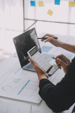 Finansal analistler, şirketlerin başarılı takım çalışmalarının sonuçlarını gösteren bir toplantıda bir dijital tablet planlama yatırım projesinin ticari mali raporlarını analiz ediyorlar..