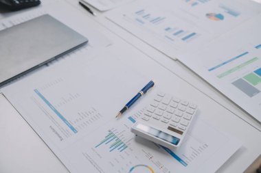 Finansal analistler, şirketlerin başarılı takım çalışmalarının sonuçlarını gösteren bir toplantıda bir dijital tablet planlama yatırım projesinin ticari mali raporlarını analiz ediyorlar..