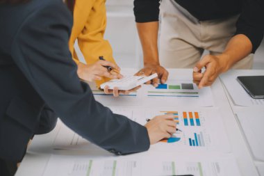 Finansal analistler, şirketlerin başarılı takım çalışmalarının sonuçlarını gösteren bir toplantıda bir dijital tablet planlama yatırım projesinin ticari mali raporlarını analiz ediyorlar..