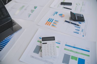 Finansal analistler, şirketlerin başarılı takım çalışmalarının sonuçlarını gösteren bir toplantıda bir dijital tablet planlama yatırım projesinin ticari mali raporlarını analiz ediyorlar..