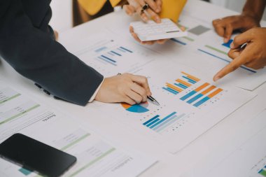 Finansal analistler, şirketlerin başarılı takım çalışmalarının sonuçlarını gösteren bir toplantıda bir dijital tablet planlama yatırım projesinin ticari mali raporlarını analiz ediyorlar..