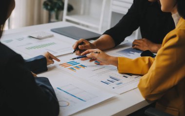 Finansal analistler, şirketlerin başarılı takım çalışmalarının sonuçlarını gösteren bir toplantıda bir dijital tablet planlama yatırım projesinin ticari mali raporlarını analiz ediyorlar..