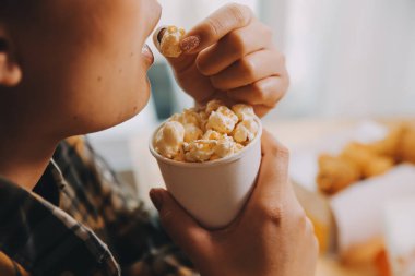 Elinde patlamış mısır kasesi tutan bir kadın.