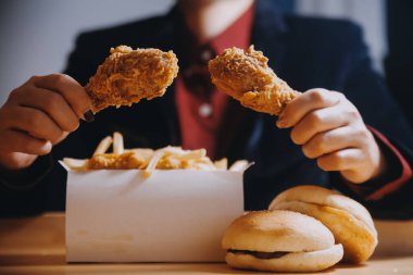 Odaklan kadın. Elin kızarmış tavuğu yemek için tutuyor. Fast food konsepti olan bir kız.