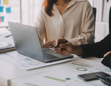 Finansal analistler, şirketlerin başarılı takım çalışmalarının sonuçlarını gösteren bir toplantıda bir dijital tablet planlama yatırım projesinin ticari mali raporlarını analiz ediyorlar..