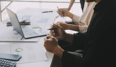 Finansal analistler, şirketlerin başarılı takım çalışmalarının sonuçlarını gösteren bir toplantıda bir dijital tablet planlama yatırım projesinin ticari mali raporlarını analiz ediyorlar..