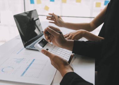 Finansal analistler, şirketlerin başarılı takım çalışmalarının sonuçlarını gösteren bir toplantıda bir dijital tablet planlama yatırım projesinin ticari mali raporlarını analiz ediyorlar..
