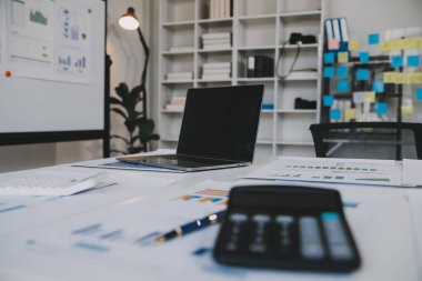 Finansal analistler, şirketlerin başarılı takım çalışmalarının sonuçlarını gösteren bir toplantıda bir dijital tablet planlama yatırım projesinin ticari mali raporlarını analiz ediyorlar..