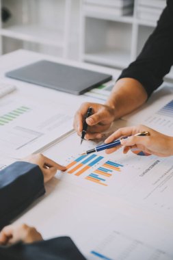 Finansal analistler, şirketlerin başarılı takım çalışmalarının sonuçlarını gösteren bir toplantıda bir dijital tablet planlama yatırım projesinin ticari mali raporlarını analiz ediyorlar..