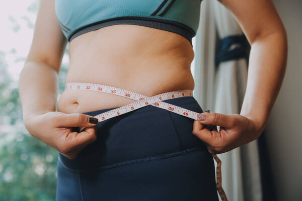 толстая женщина, жирный живот, пухлый, толстая женщина рука держит избыточный жир живота с помощью ленты, женщина диета образ жизни