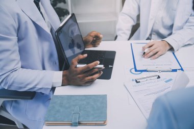 Görüşme, tablet ve doktorlardan oluşan bir ekip sağlık hizmetlerinden ve tele-sağlık uygulamalarından konuşmak için ofiste. Hastane finansmanı veya sponsorluğu için internet sitesiyle cerrah grubu, teknik ve tıbbi tartışmalar